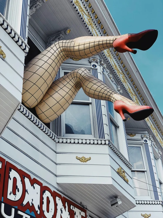 a statue of a woman hanging from the side of a building, inspired by David LaChapelle, trending on pexels, maximalism, fishnets stockings, photograph of san francisco, terry richardson, shopwindows