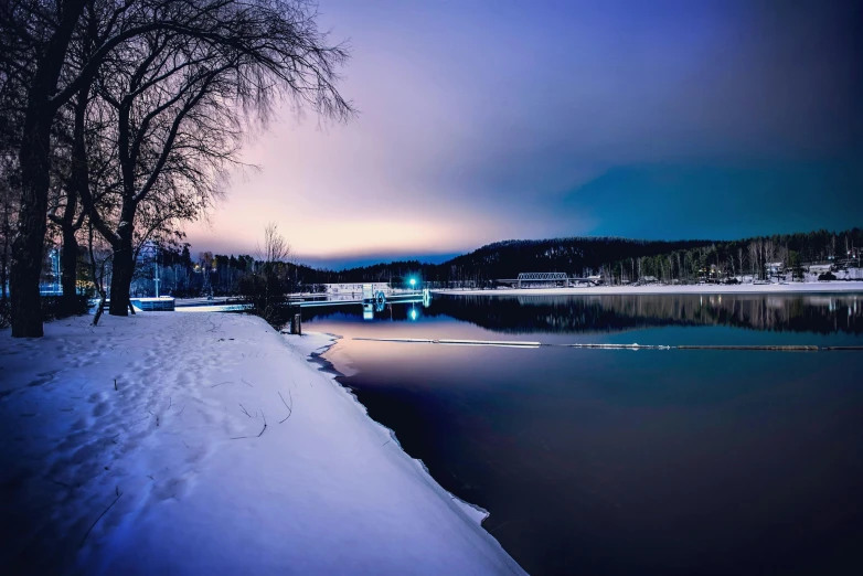 a body of water surrounded by snow covered ground, by Jesper Knudsen, pexels contest winner, twilight cool light, big bear lake california, urban surroundings, cold color