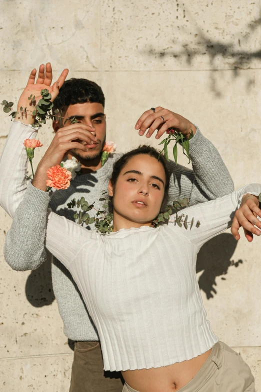 a man and a woman standing next to each other, an album cover, pexels contest winner, flowers growing out of his body, battle pose, hispanic, four hands