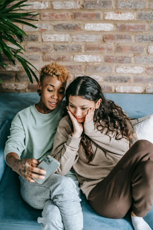 two women sitting on a couch looking at a cell phone, trending on pexels, happening, lesbian embrace, sad men, essence, instagram photo