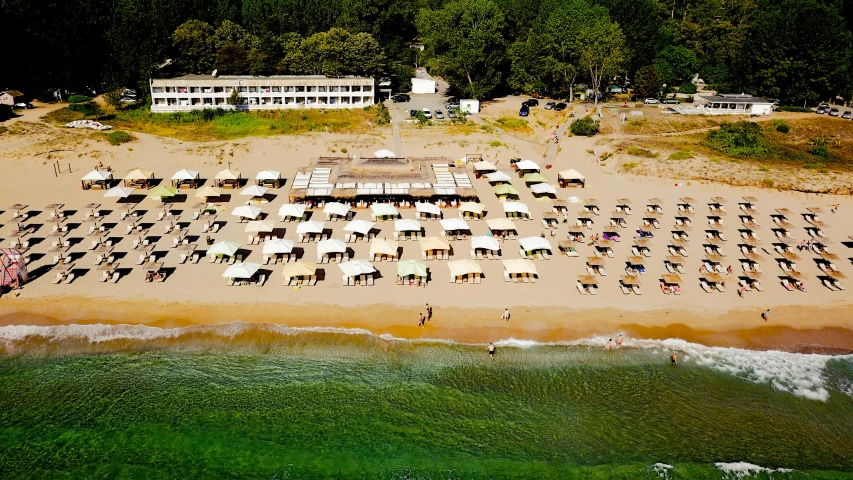 an aerial view of a beach with umbrellas and chairs, bulgari, exterior photo, summer camp, restaurant