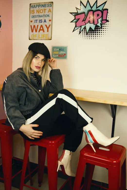 a woman sitting on top of a red stool, inspired by Elsa Bleda, trending on pexels, pop art, wearing rr diner uniform, she is wearing streetwear, transgender, standing in corner of room