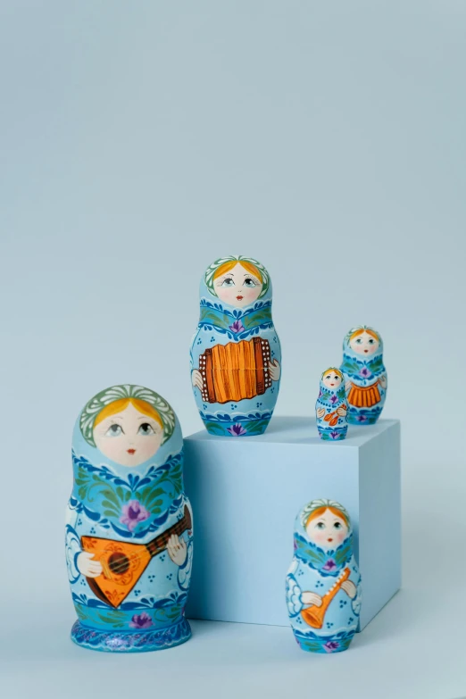 a group of russian nesting dolls sitting next to each other, a still life, by Sam Havadtoy, blue!! with orange details, official product photo, petite girl, tall shot