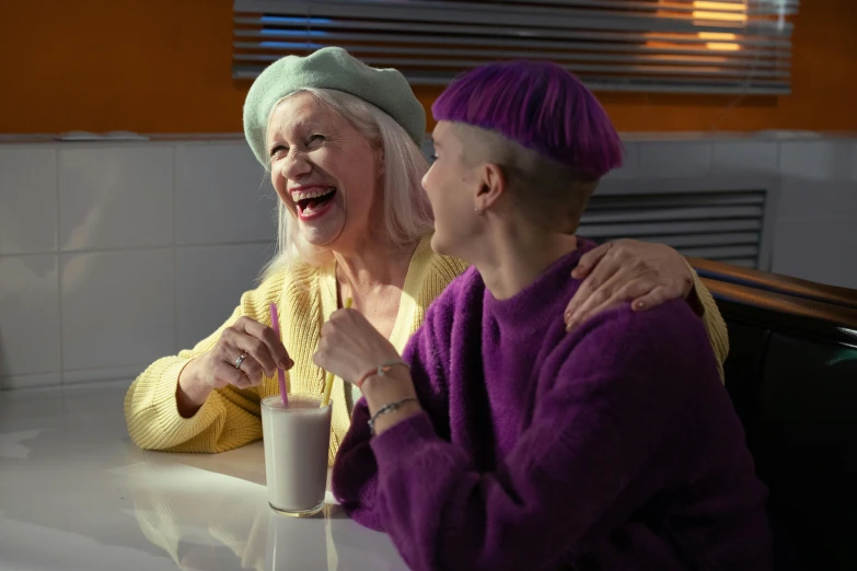 a couple of women sitting next to each other at a table, trending on pexels, antipodeans, wearing a purple cap, albino skin, milkshake, older woman