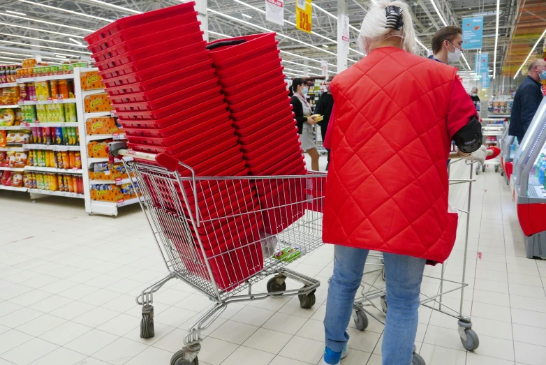 a man in a red jacket pushing a shopping cart, pexels, bauhaus, ikea style, russia in 2 0 2 1, stacking supermarket shelves, big crowd