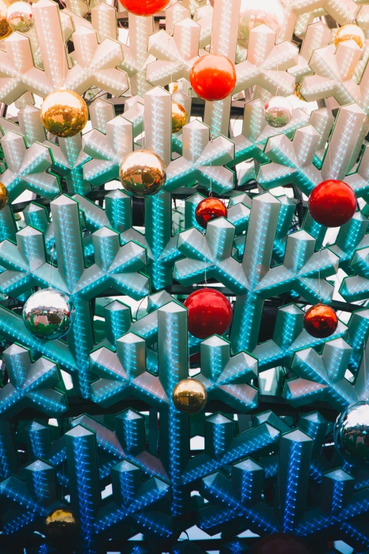 a bunch of christmas ornaments sitting on top of a table, an abstract sculpture, by Jessie Algie, pexels contest winner, kinetic art, hexagonal pattern, mall, teal silver red, christmas tree