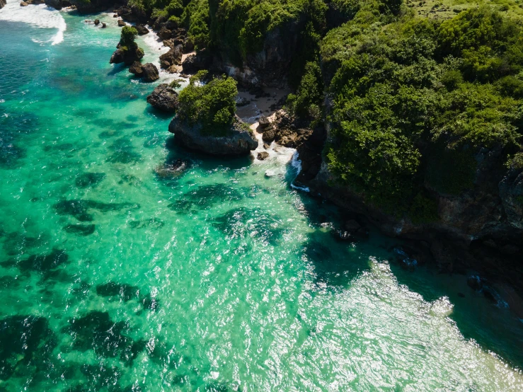 a large body of water next to a lush green hillside, pexels contest winner, hurufiyya, white beaches, crystal clear neon water, flying rocky island, conde nast traveler photo