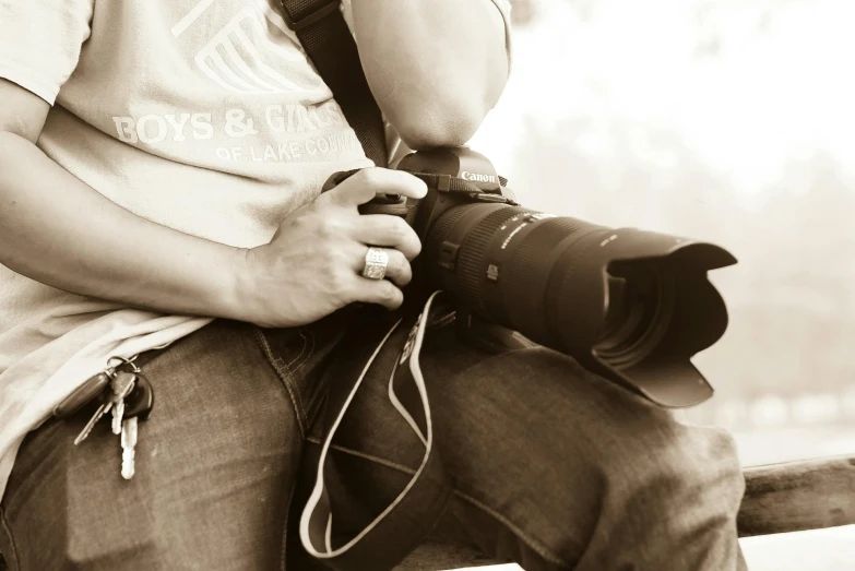 a man sitting on a bench holding a camera, professional photo-n 3, sepia photography, macro photography 8k, shot on sony a 7
