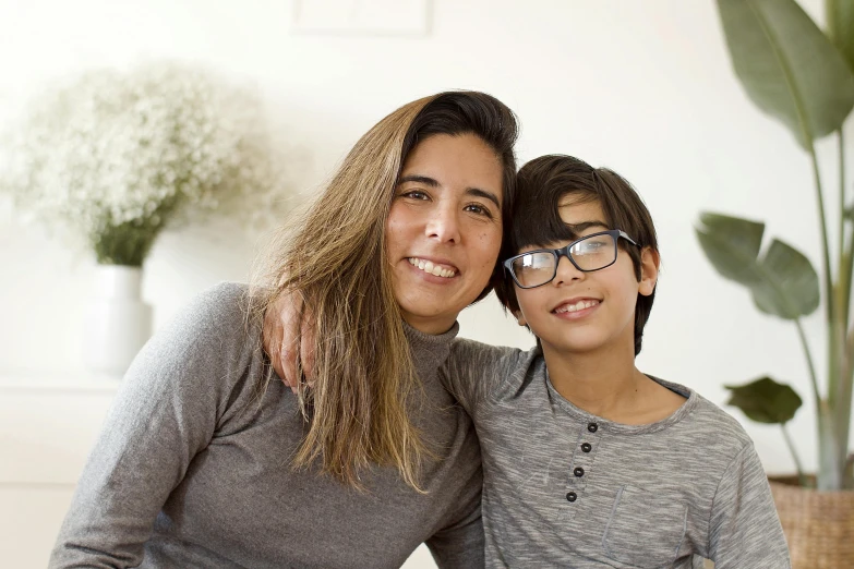 a woman and a boy are posing for a picture, glasses |, spanish, profile image, at home