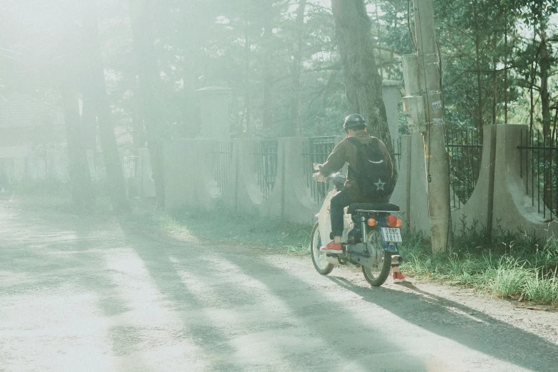 a man riding on the back of a motorcycle down a street, inspired by Elsa Bleda, unsplash contest winner, light green mist, japan rural travel, 🚿🗝📝