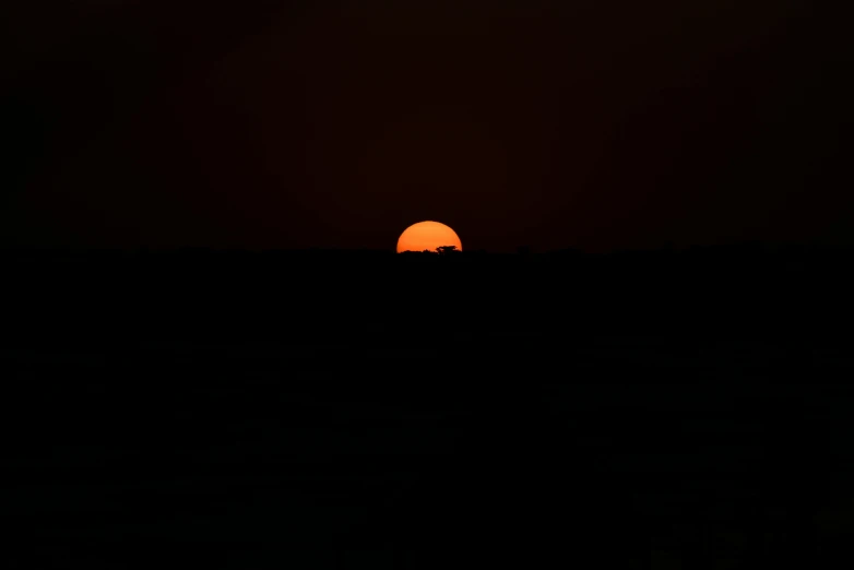 the sun is setting in the dark sky, a picture, by Attila Meszlenyi, minimalism, big red sun, horizon, strange craft above the horizon, uploaded