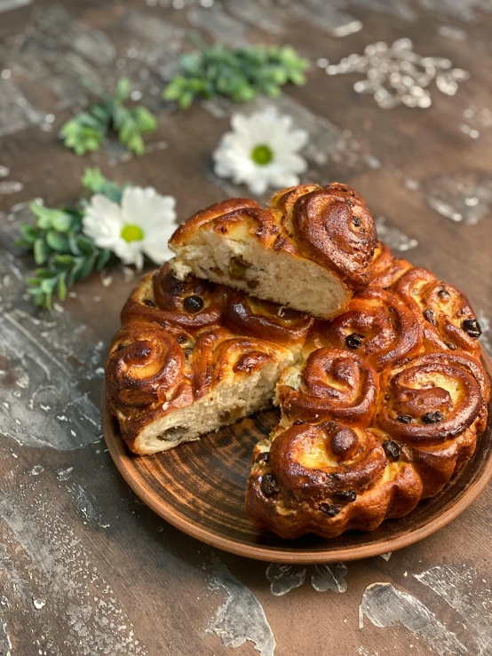 a close up of a plate of food on a table, in the shape of a cinnamon roll, 中 元 节, cursed baroque with ebony inlay, loaves