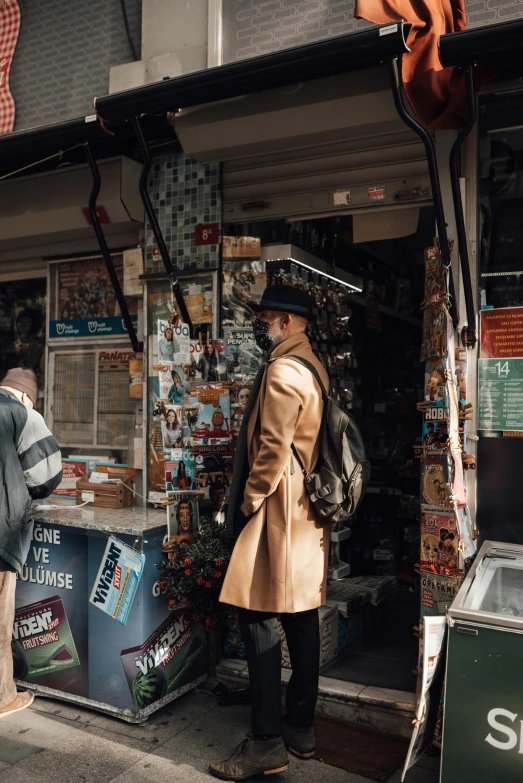 a couple of people standing in front of a store, trending on pexels, detective coat, in chippendale sydney, knick knacks, caracter with brown hat