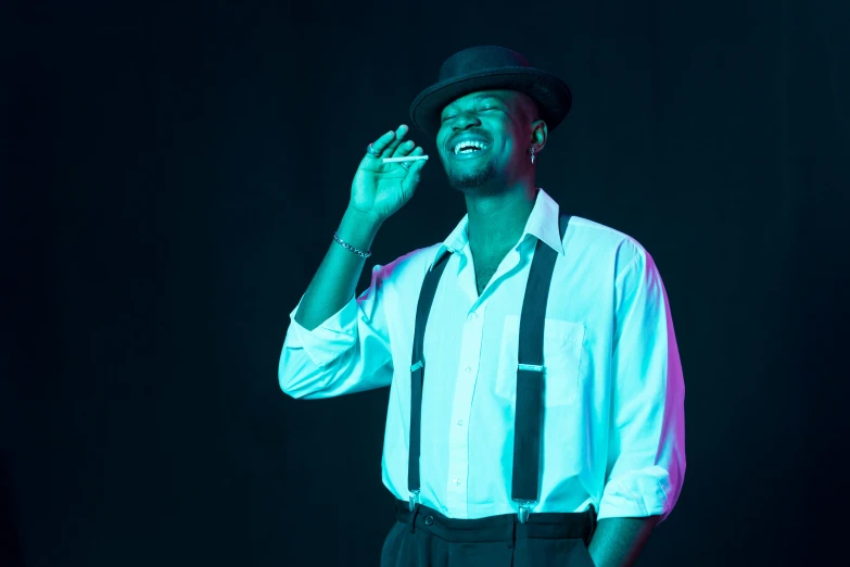 a man in a white shirt and black suspenders talking on a cell phone, an album cover, inspired by Theo Constanté, pexels contest winner, harlem renaissance, blue fedora, dramatic smile pose, under a spotlight, ( ( dark skin ) )