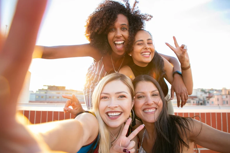 a group of women making a peace sign with their hands, trending on pexels, selfie of a young woman, laughing your head off, on rooftop, brown