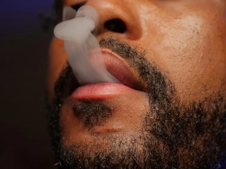 a close up of a man with a cigarette in his mouth, mc ride, liquid smoke twisting, sage smoke, scruffy beard