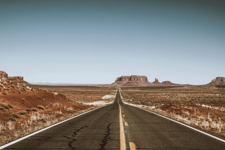 an empty road in the middle of a desert, by Daniel Lieske, pexels contest winner, hyperrealism, monument valley landscape, background image, clear skies in the distance, fine art print