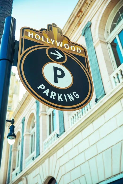 a sign on a pole in front of a building, by Lynn Pauley, trending on unsplash, art nouveau, hollywood scene, parking in the street, 2 5 6 x 2 5 6 pixels, hi-res