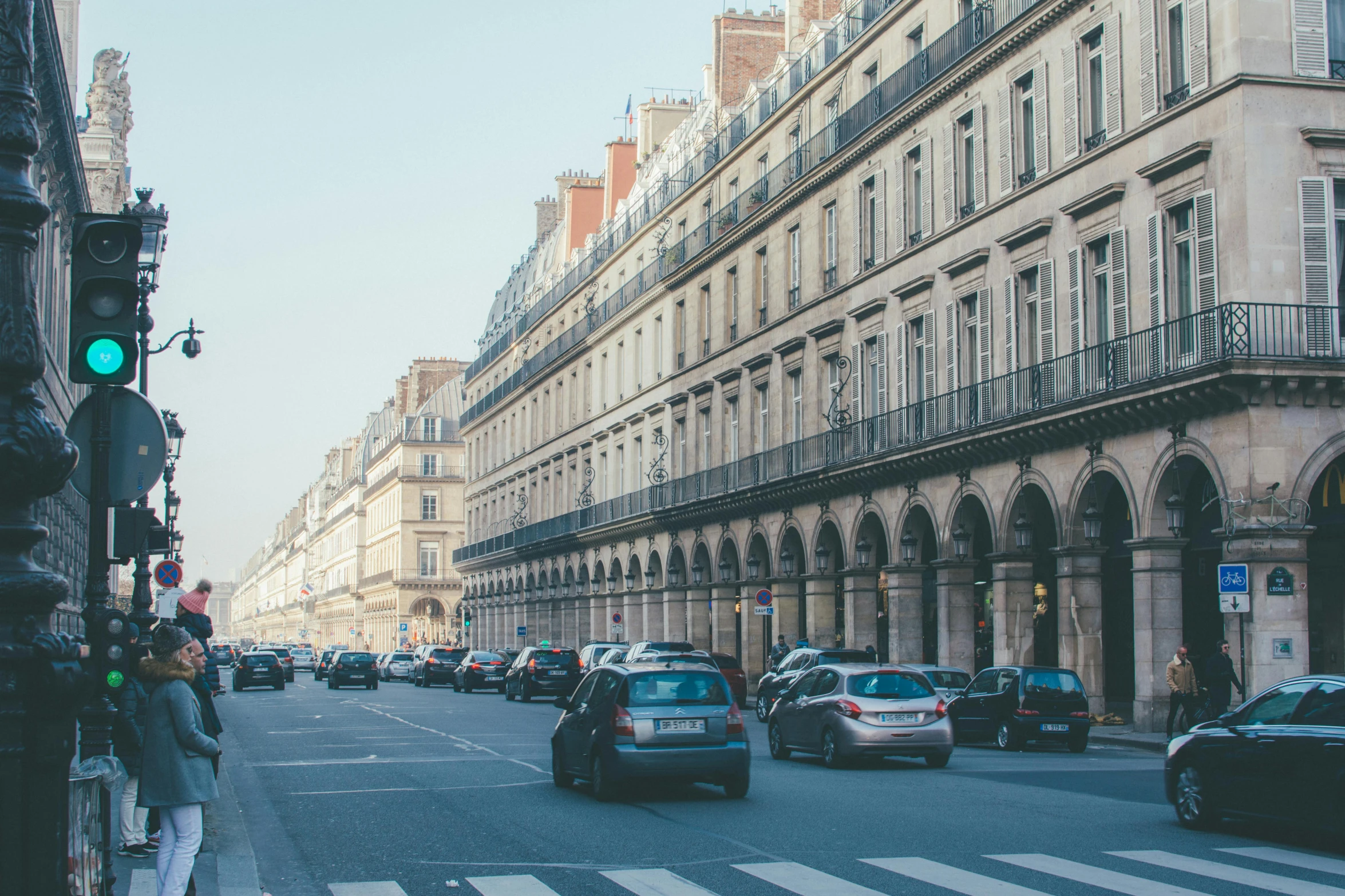 a street filled with lots of traffic next to tall buildings, by Raphaël Collin, pexels contest winner, neoclassicism, splendid haussmann architecture, square, slide show, slightly sunny