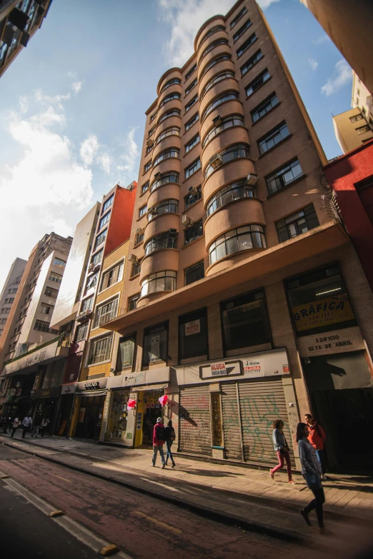 a group of people walking down a street next to tall buildings, quito school, bladerunner apartment, brown, exterior view, talaat harb square cairo