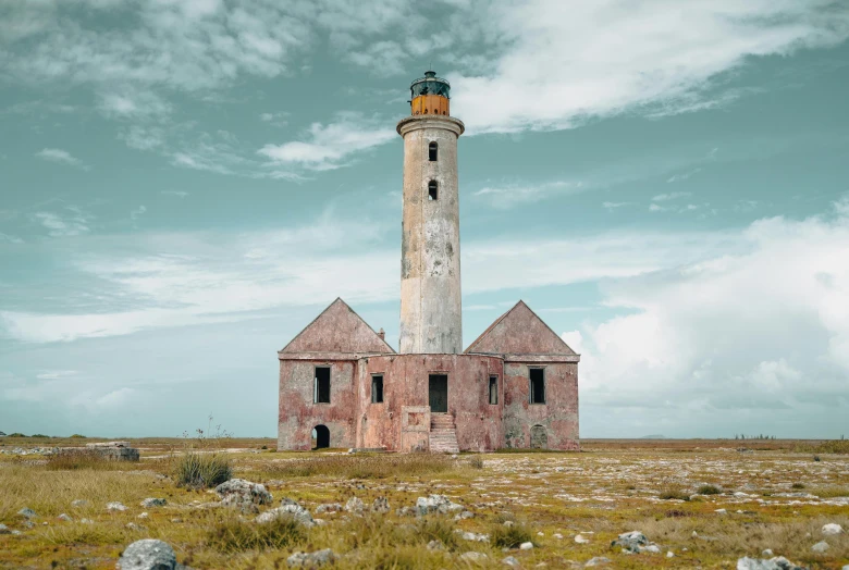 a light house sitting on top of a grass covered field, a colorized photo, by Lubin Baugin, pexels contest winner, aruba, “derelict architecture buildings, medium format color photography, a tall
