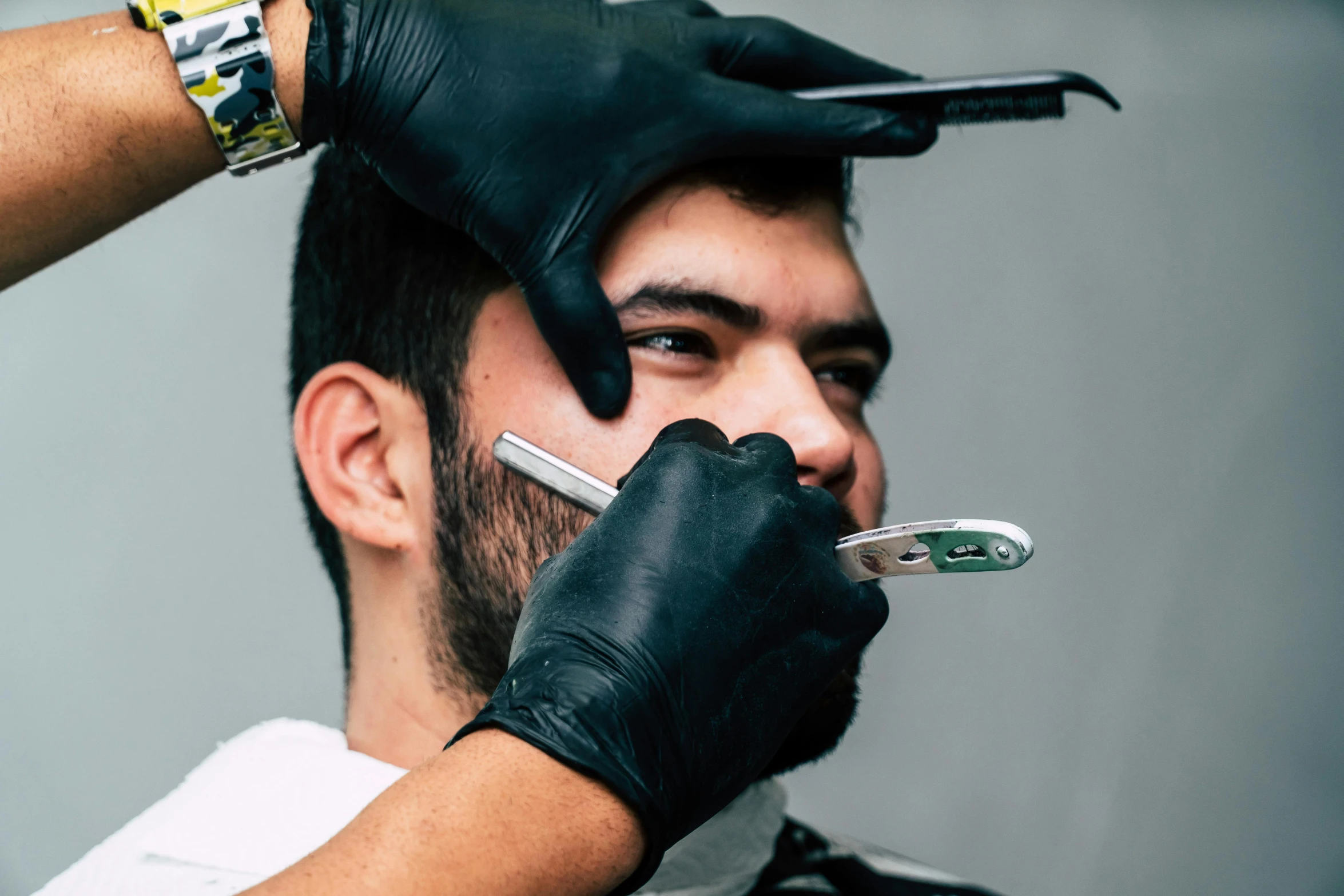 a man getting his hair cut by a barber, by Adam Marczyński, trending on pexels, hyperrealism, square masculine jaw, avatar image, middle eastern skin, hands shielding face