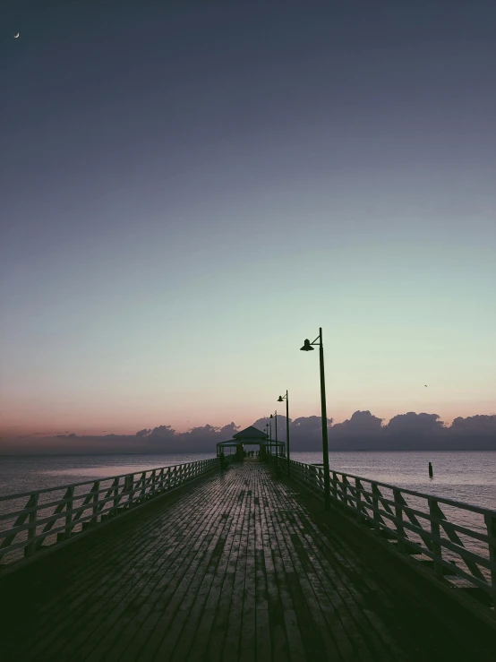 a pier that is next to a body of water, by Niko Henrichon, unsplash contest winner, romanticism, humid evening, pov photo, skies, today\'s featured photograph 4k