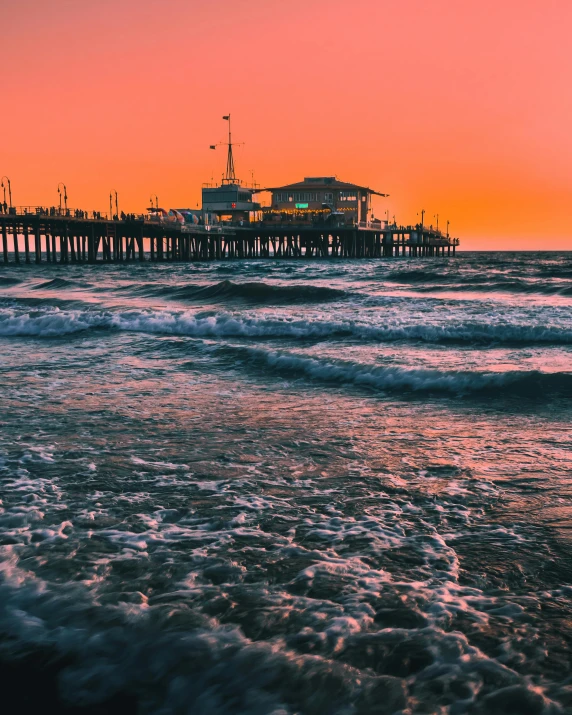 a sunset over the ocean with a pier in the background, pexels contest winner, it's californication, ocean spray, a photo of sephiroth, lgbtq