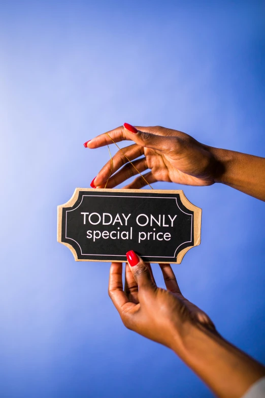a woman holding a sign that says today only special price, by Julia Pishtar, private press, professional studio photograph, blue sky, multi-part, product display photograph