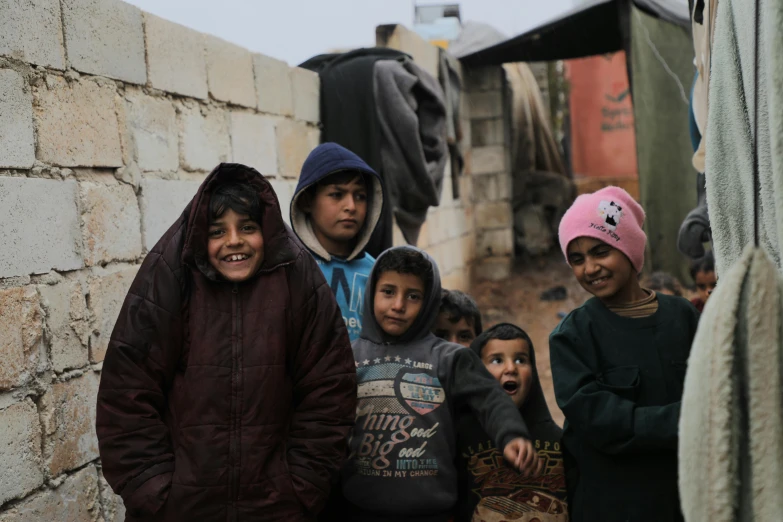 a group of people standing next to each other, pexels contest winner, hurufiyya, children, balaclava, settlement, promo image