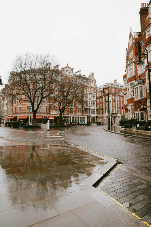 a wet street with buildings in the background, by Nina Hamnett, unsplash, on a great neoclassical square, panoramic, 1920's london street, red square