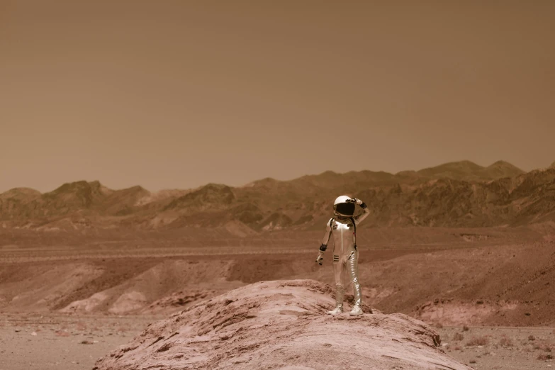 an astronaut standing on a rock in the desert, a colorized photo, pexels contest winner, sepia colors, overlooking martian landscape, brown, venus surface