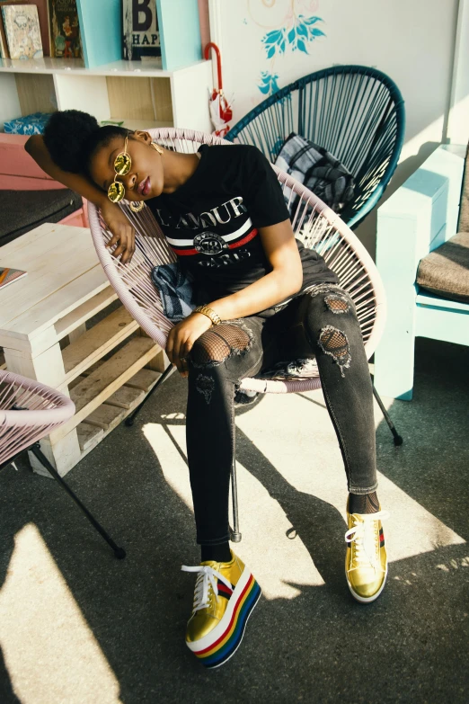 a woman sitting on a chair in a room, by Dulah Marie Evans, trending on pexels, streetwear fashion, black and yellow and red scheme, poolside, androgynous male