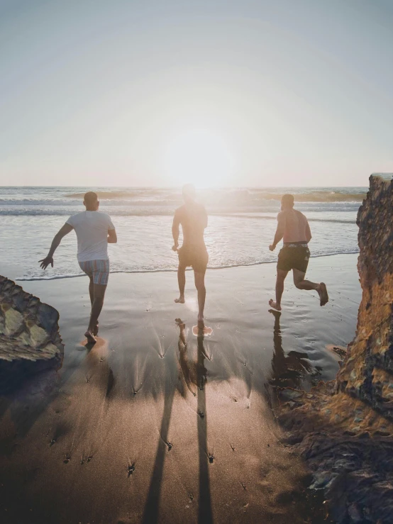 three people running on the beach at sunset, by Jessie Algie, pexels contest winner, masculinity, hollister ranch, high angle shot, profile image