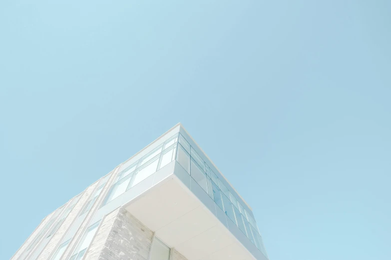 a tall white building with a blue sky in the background, a minimalist painting, unsplash contest winner, light and space, glass skin, pastel hues, camera looking up, looking to the side