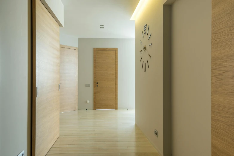 a long hallway with a clock on the wall, a 3D render, unsplash, light and space, wood door, beige, volumetric lighting - n 9, apartment