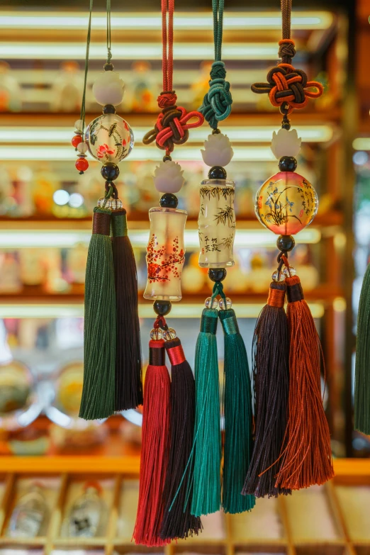 a bunch of tassels hanging from a rack, inspired by Cui Bai, trending on pexels, cloisonnism, lush surroundings, in magnificent shopping mall, lots of glass details, headshot