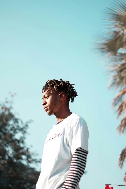 a man riding a skateboard down the side of a road, an album cover, by Charles Martin, trending on pexels, halfbody headshot, palms, immature, looking at the sky