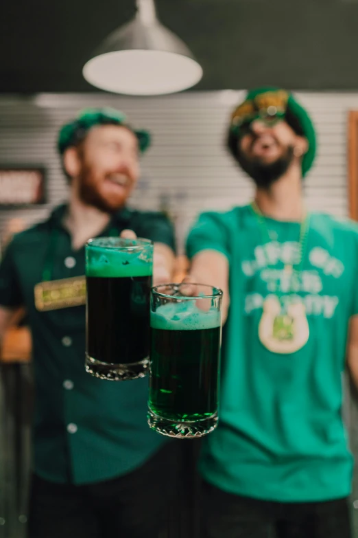 a couple of men standing next to each other holding glasses of beer, green and black colors, 🚀🌈🤩, irish, green head