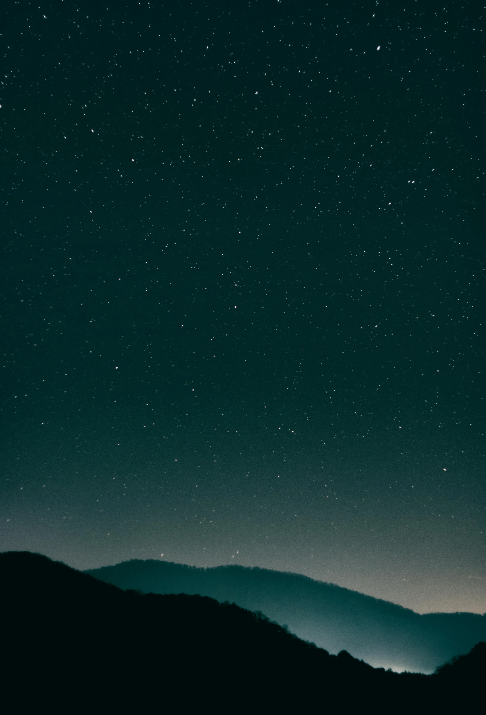 a person standing on top of a mountain under a night sky, inspired by Elsa Bleda, minimalism, 2 5 6 x 2 5 6 pixels, teal aesthetic, tiny stars, unsplash photography