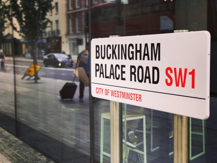 a white street sign sitting on the side of a road, by Roger Swainston, shutterstock, suprematism, interior of buckingham palace, bus station, switch, profile image