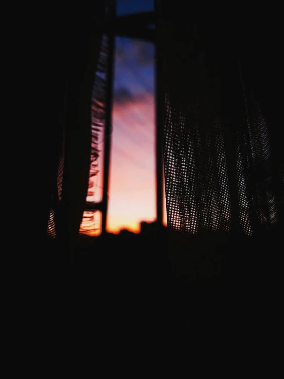 a window with a sunset in the background, inspired by Elsa Bleda, dark drapery, album cover, low quality photo, photo on iphone