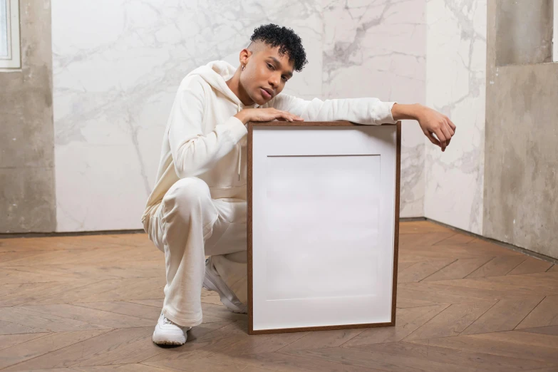 a man posing with a picture frame in a room, an album cover, inspired by Nathaniel Pousette-Dart, white box, wearing a tracksuit, product introduction photo, smooth panelling