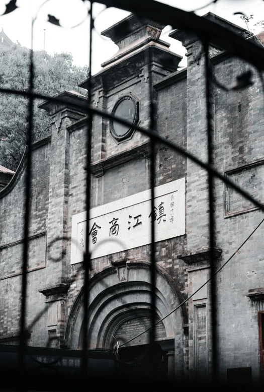 a black and white photo of an old building, an album cover, inspired by Hu Jieqing, pexels contest winner, behind bars, churches, entrance to 1900's mine, color photo