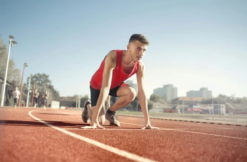 a man getting ready to run on a track, pexels contest winner, renaissance, wearing red shorts, profile image, thumbnail, looking towards camera