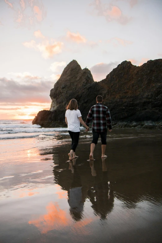 a couple walking along the beach holding hands, by Jessie Algie, unsplash contest winner, oregon, on the ocean water, te pae, prop rocks