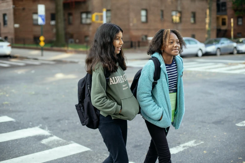 a couple of women walking across a street, trending on unsplash, american barbizon school, black teenage girl, girl wearing hoodie, ignant, humans of new york