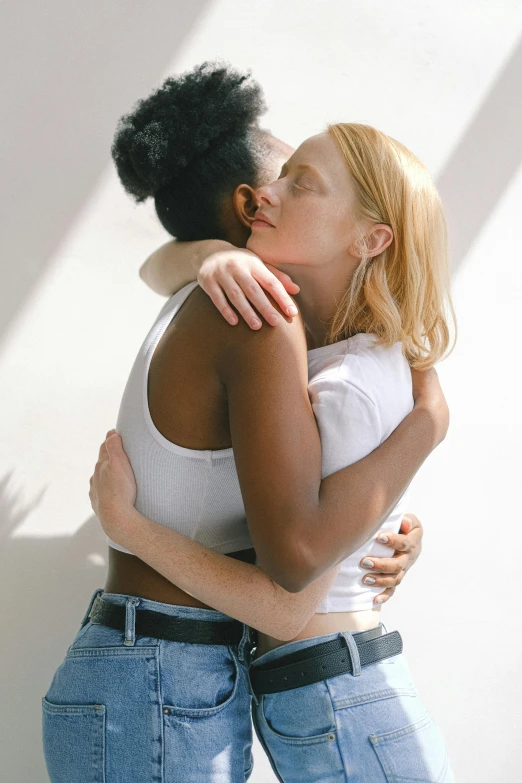 a couple of women standing next to each other, by Carey Morris, trending on unsplash, renaissance, lesbian kiss, hugging, diverse, pale light