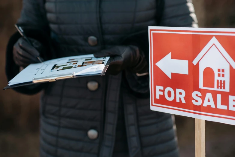 a woman holding a clipboard in front of a for sale sign, by Matt Cavotta, pexels, square, street signs, foam, an intricate