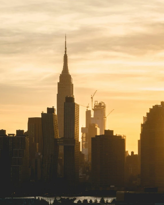 a large body of water with a city in the background, by Adam Rex, unsplash contest winner, hypermodernism, golden hour in manhattan, lgbtq, tall spires, view from the streets